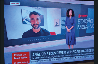 TV news set with David Nemer on screen behind female news anchor