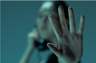 Woman on the phone holding her hand out as if to say stop